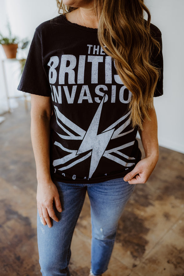 Jamie wears the Recycled Karma British Invasion graphic tee, a black oversized t-shirt with the text "The British Invasion" 