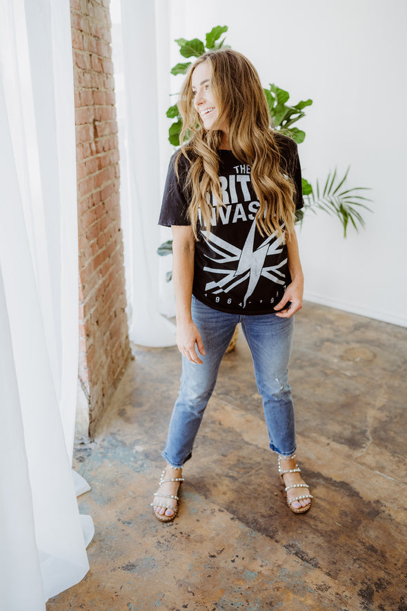 Jamie wears the Recycled Karma British Invasion graphic tee, a black oversized t-shirt with the text "The British Invasion" 